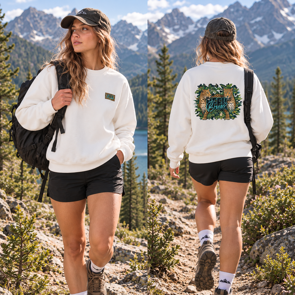 Woman wearing the white WILD crewneck with a backpack on a mountain trail