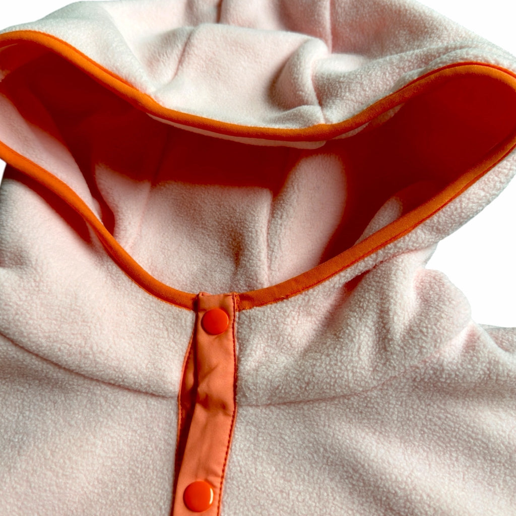 Woman wearing the Blush fleece dress in blush pink, ivory and coral