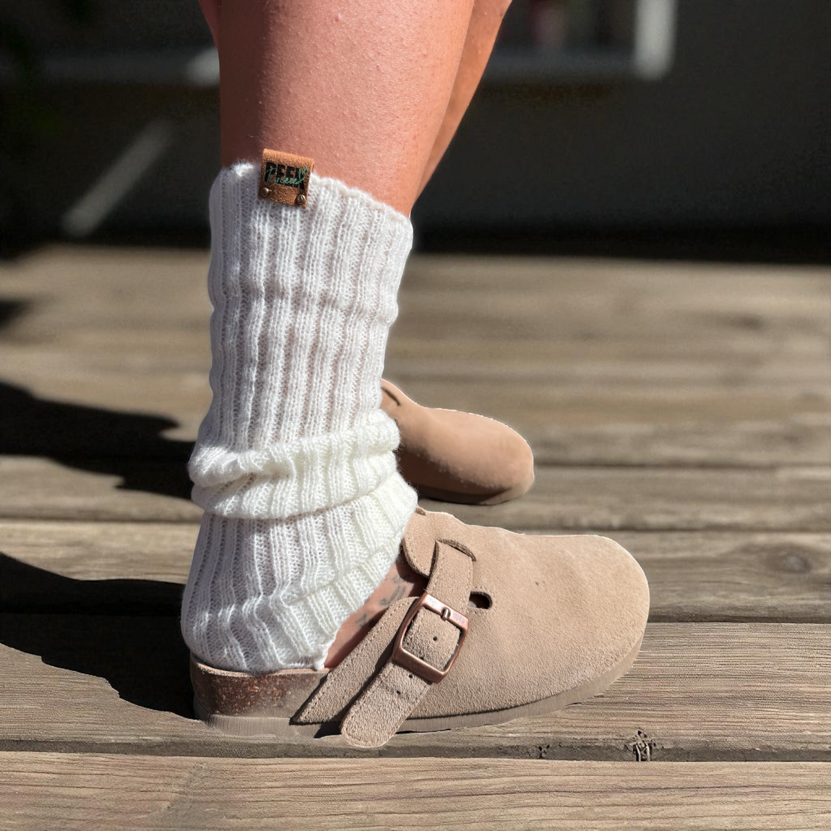 Ivory ribbed leg warmers worn with beige clogs, side view