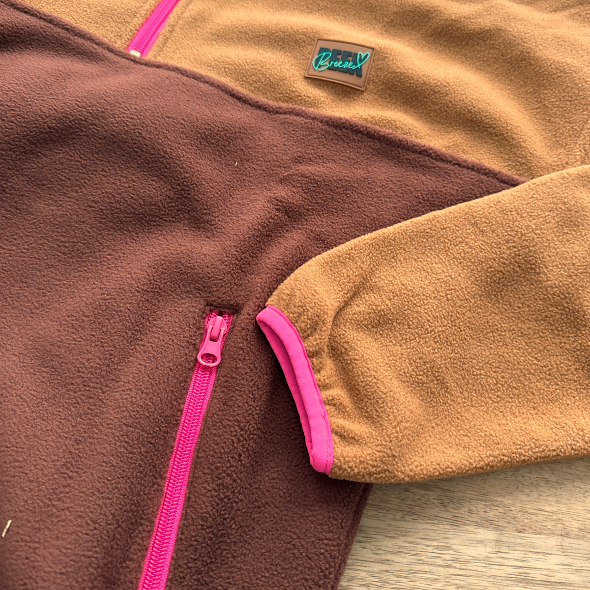 Close-up of the fuchsia zippered pocket on the Toffee fleece pullover