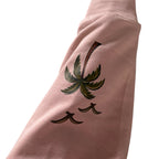 Close-up of the palm tree and birds print on the Coastal crewneck sleeve