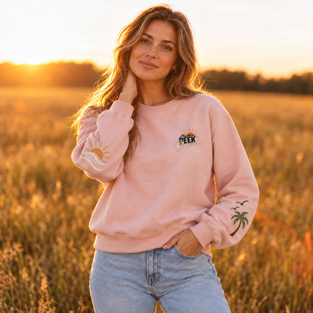 Woman wearing the pale pink Coastal crewneck with chest logo outdoors