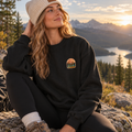 Woman wearing the black ROAM crewneck outdoors in the mountains