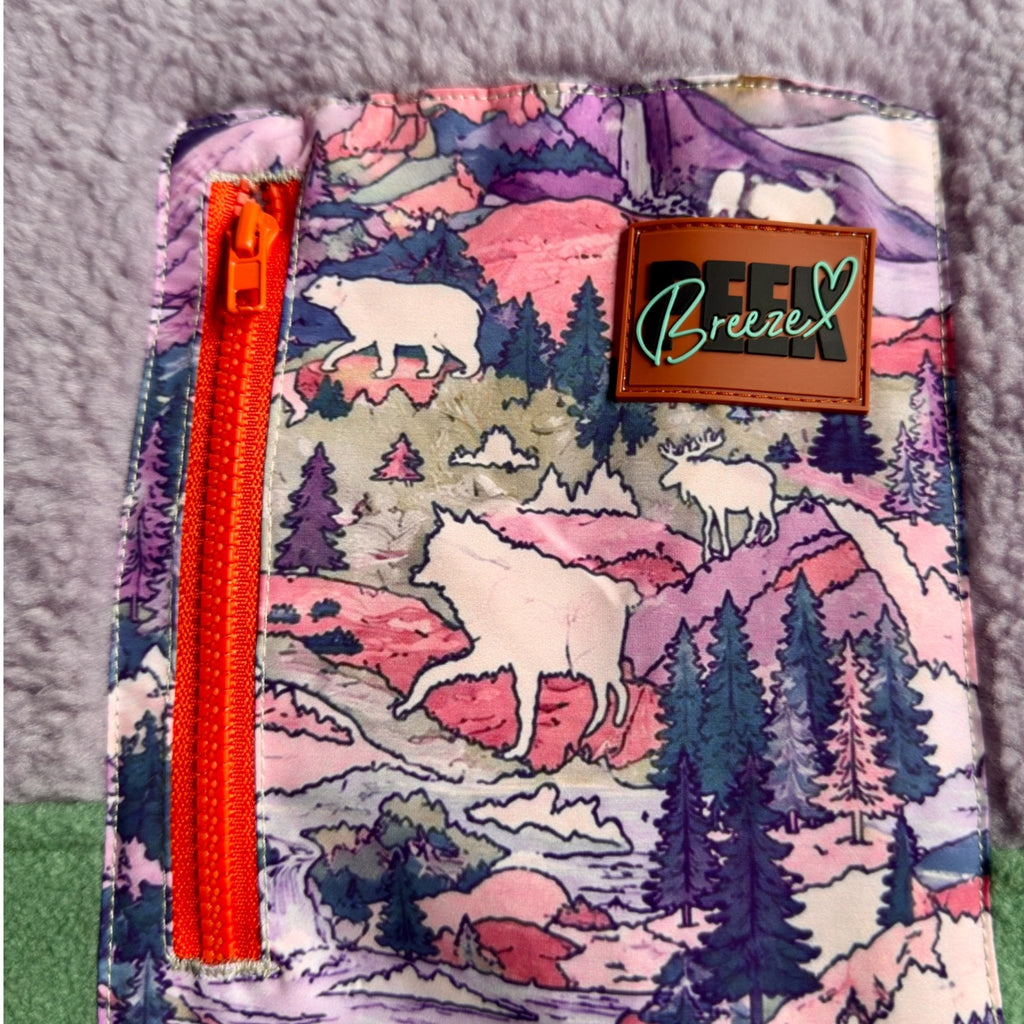 Close-up of the nature-print chest pocket with orange zipper and Peek Breeze label on the Aspen dress