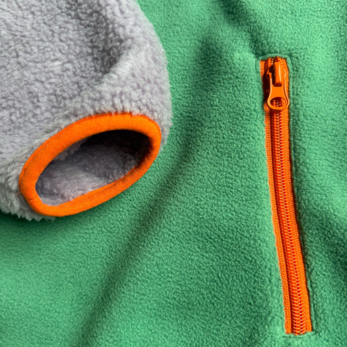 Close-up of the zippered side pocket with green fleece and lavender sherpa on the Aspen dress