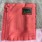 Close-up of the pink zippered pocket and Peek Breeze label on the sherpa of the Peachy dress