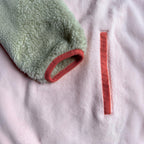 Close-up of the side pocket with blush pink fleece, sherpa sleeve and coral trim on the Peachy dress