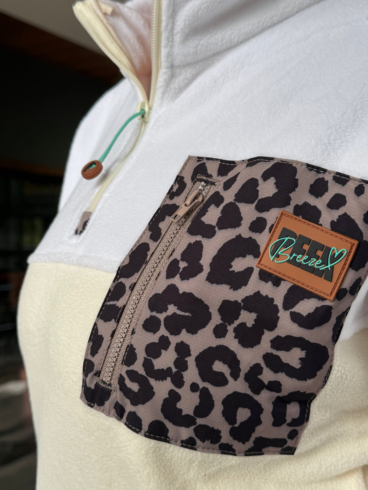 Close-up of the leopard chest pocket and half-zip on the Savana fleece dress