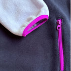 Close-up of the fuchsia cuff trim and zippered side pocket on the navy fleece