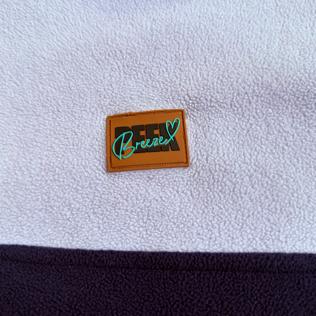 Peek Breeze logo patch on soft lilac fleece above the navy panel
