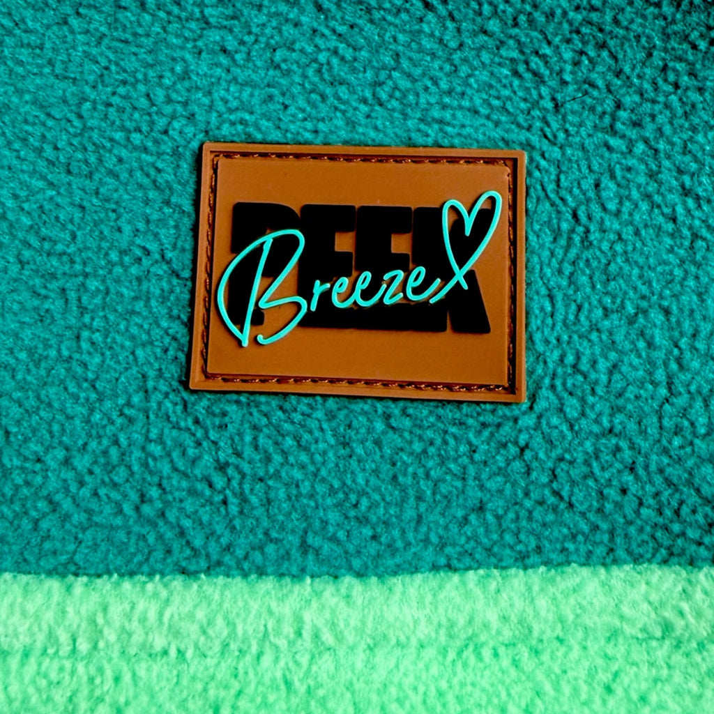 Peek Breeze logo patch on forest green fleece above the mint panel