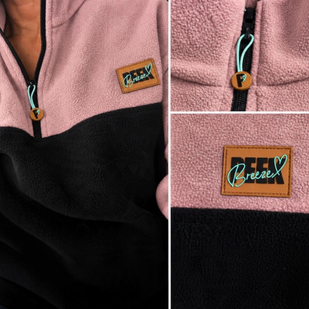 Close-up details of the black quarter-zip, logo zipper pull and Peek Breeze patch on dusty rose fleece