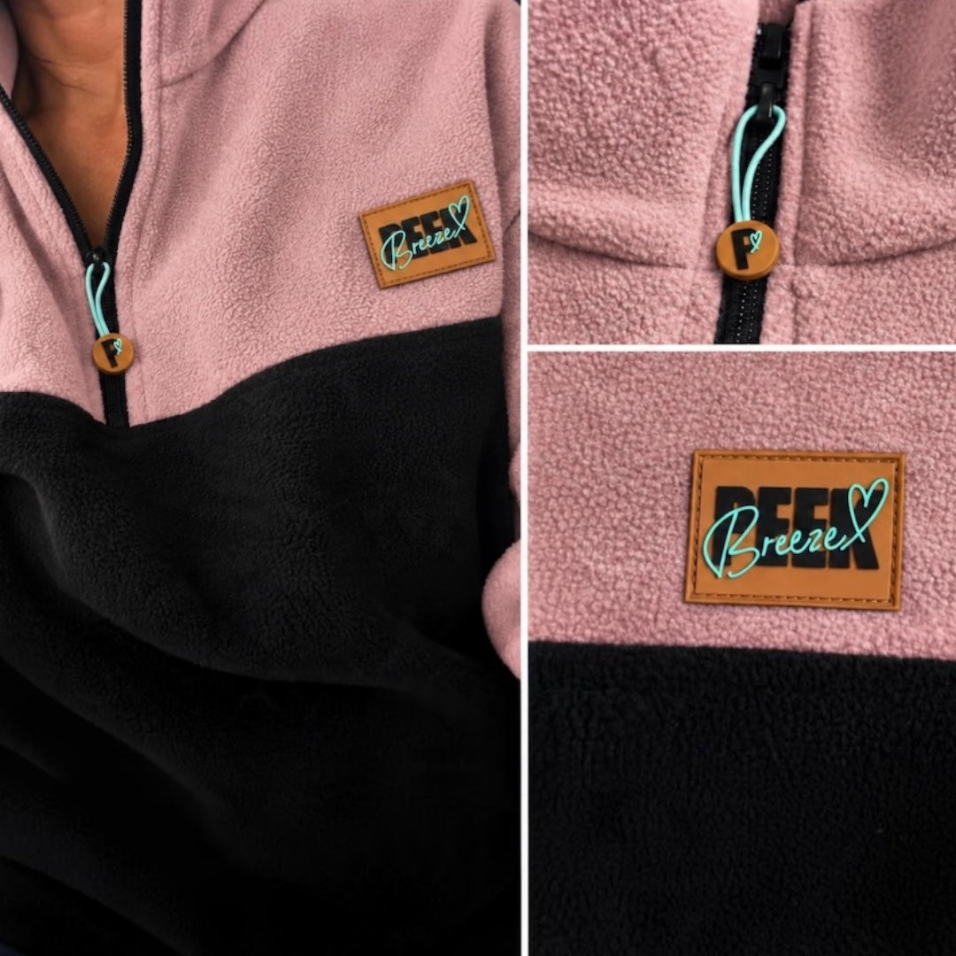 Close-up details of the black quarter-zip, logo zipper pull and Peek Breeze patch on dusty rose fleece