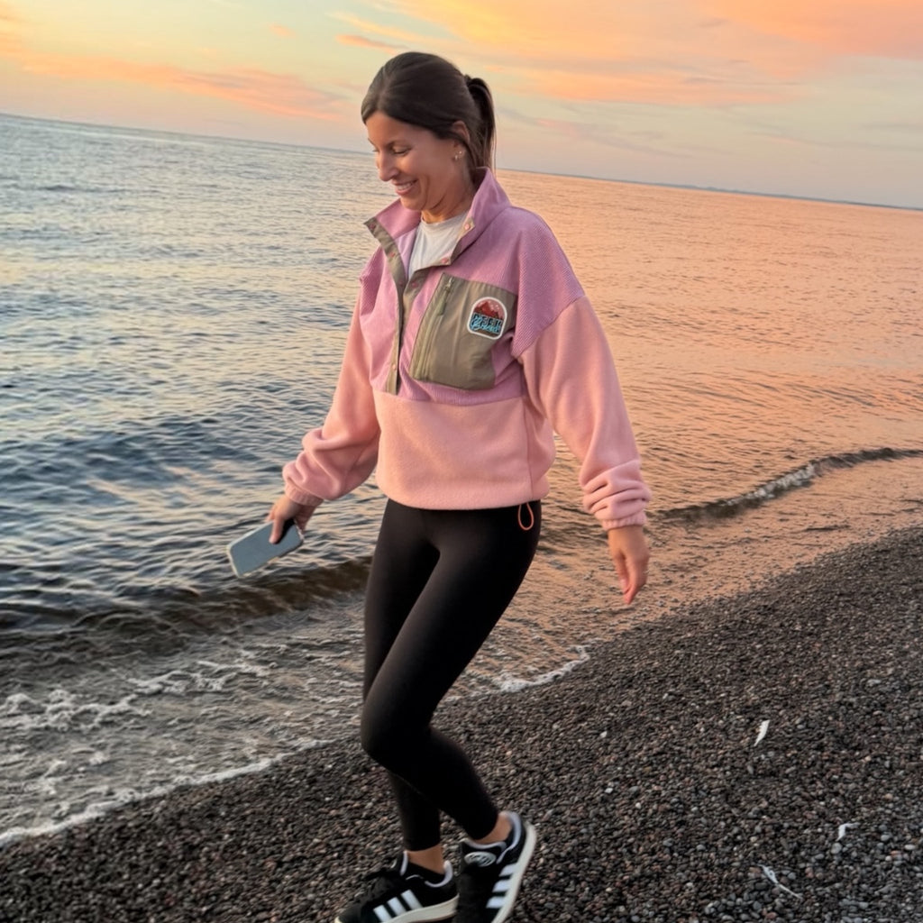 Woman wearing the Boreal pink fleece pullover with corduroy details by the sea