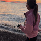 Back view of the Boreal pink corduroy fleece pullover worn by the sea