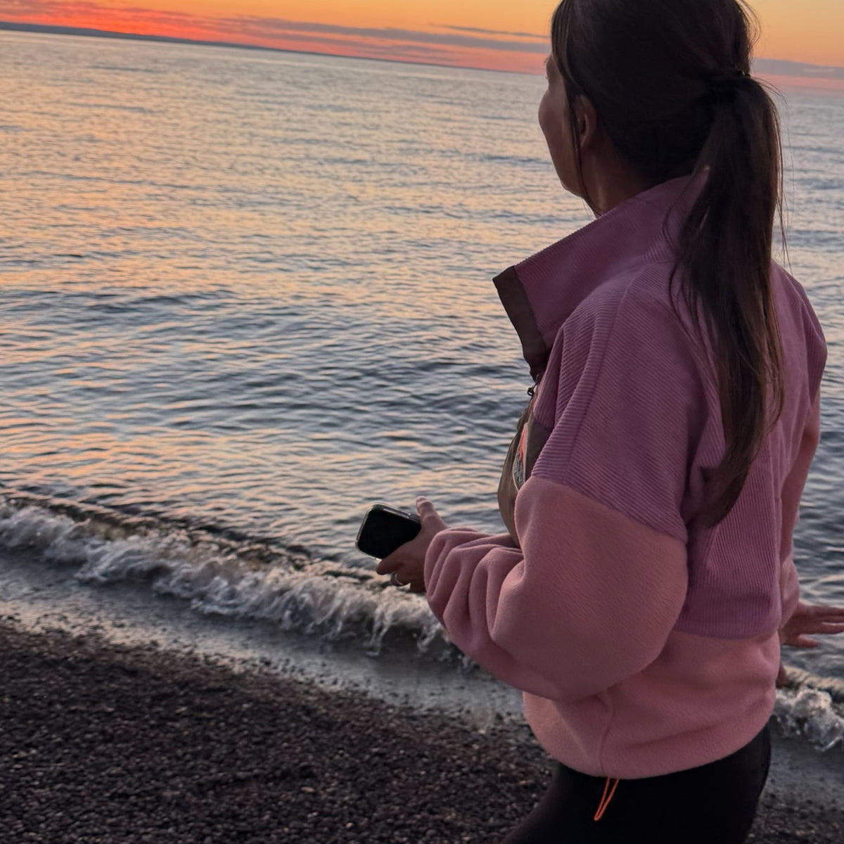 Back view of the Boreal pink corduroy fleece pullover worn by the sea