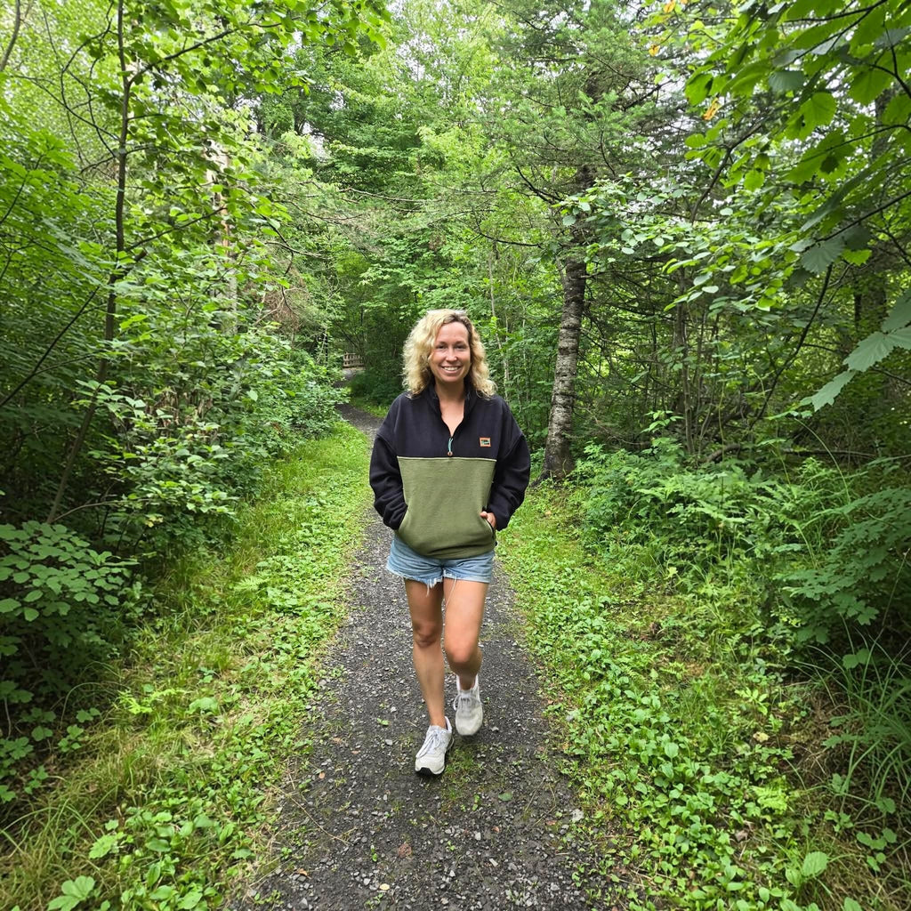 Woman wearing the Haven black and khaki fleece pullover on a forest walk