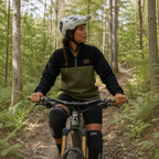Woman wearing the Haven black and khaki fleece pullover mountain biking in the forest