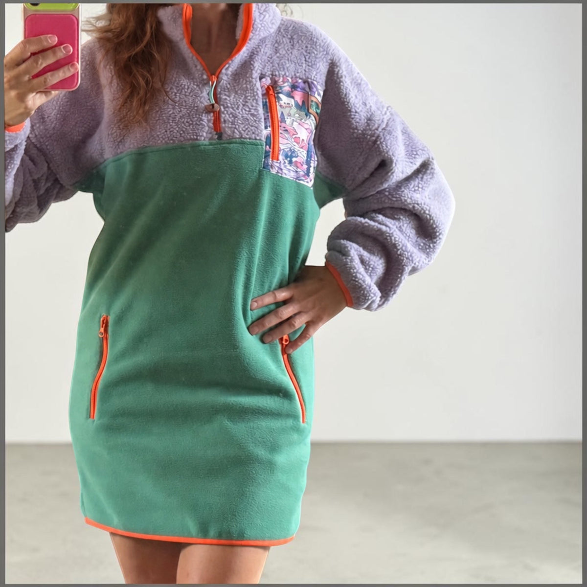 Woman wearing the Aspen dress with lavender sherpa top, green fleece bottom and orange zippers