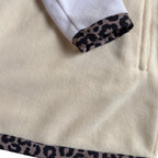 Close-up of the cream fleece, leopard trim and side pocket on the Savana dress