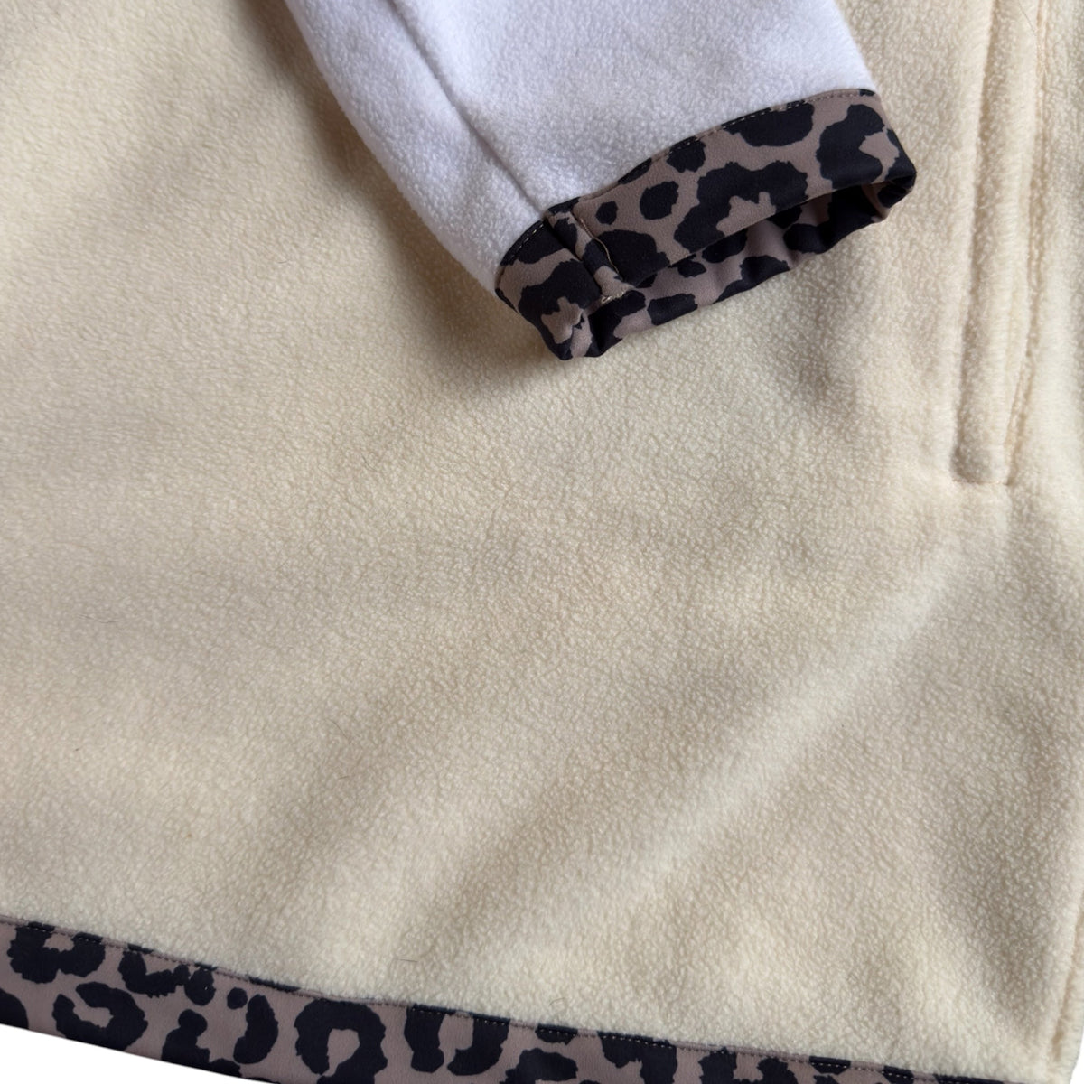 Close-up of the cream fleece, leopard trim and side pocket on the Savana dress