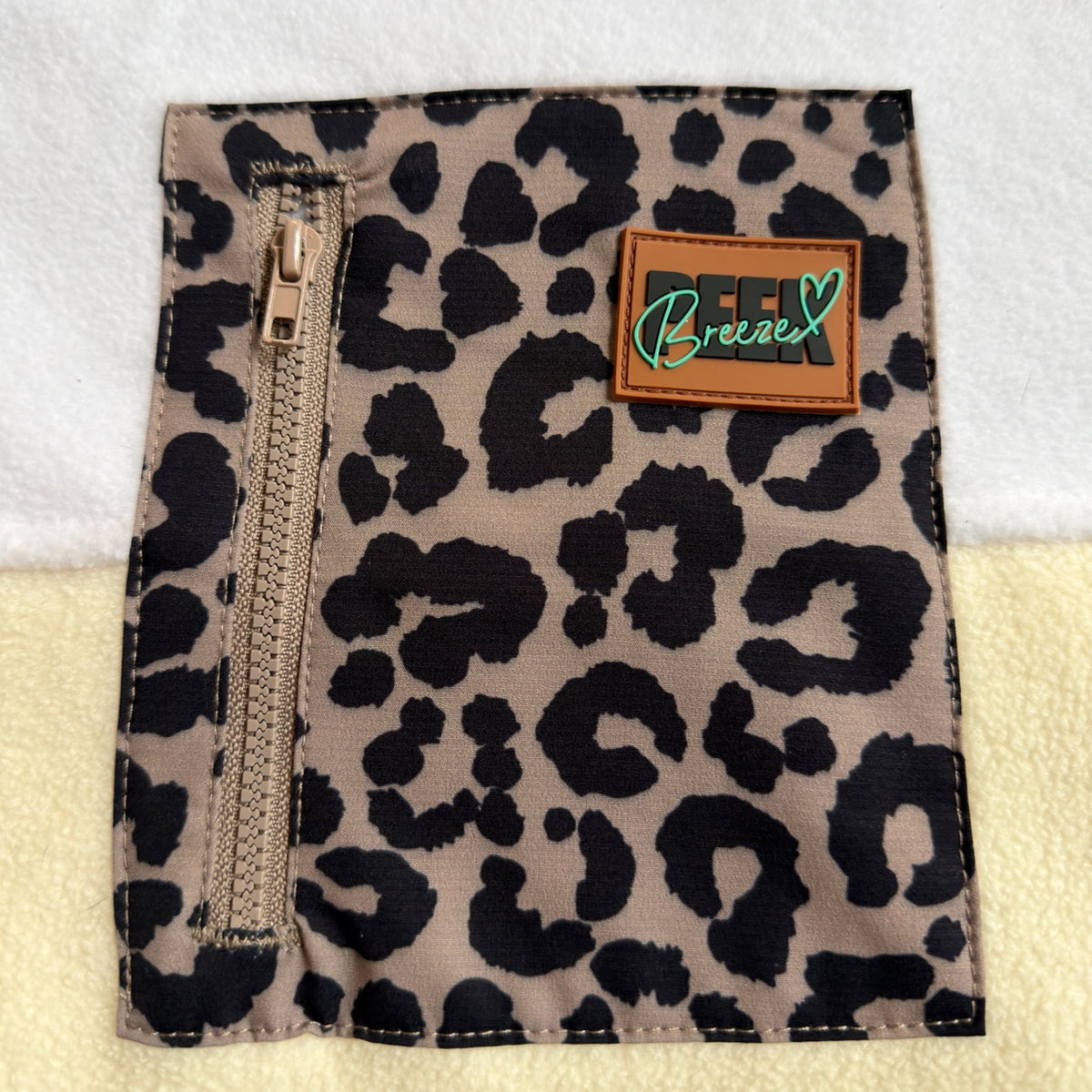 Close-up of the leopard print zippered chest pocket and brand label on the Savana dress