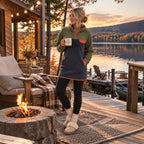 Woman wearing the Retro khaki and navy fleece dress by an outdoor fire at the cabin